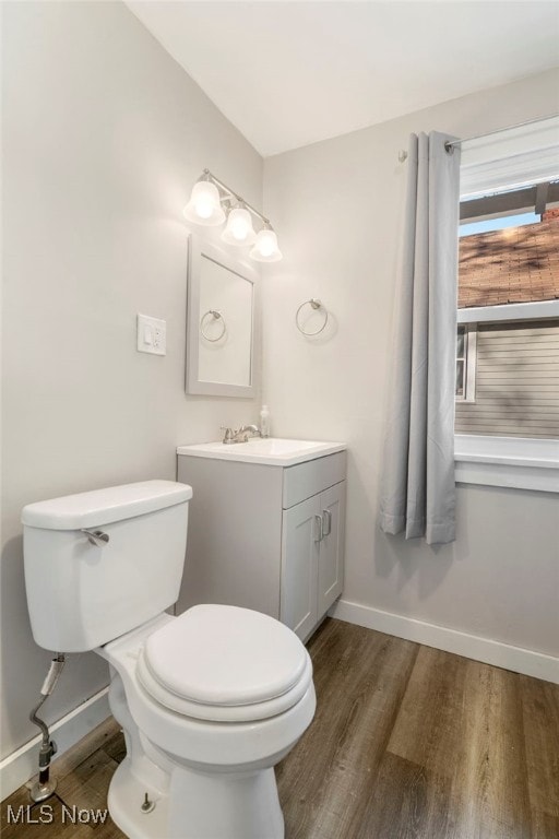 bathroom featuring toilet, wood-type flooring, and vanity