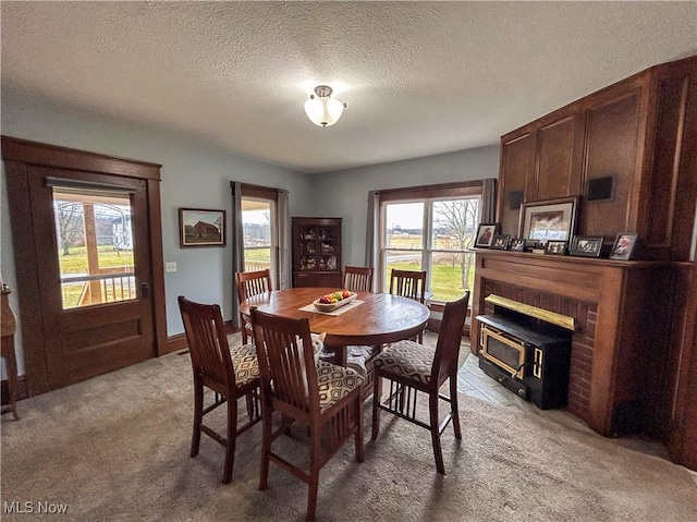 dining space featuring light carpet and a textured ceiling