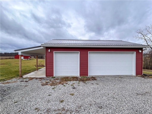 garage featuring a yard and a carport