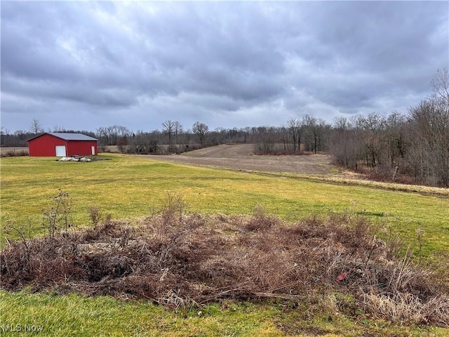 view of yard with a rural view and an outbuilding