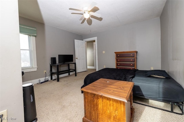 bedroom with a textured ceiling, ceiling fan, and light carpet