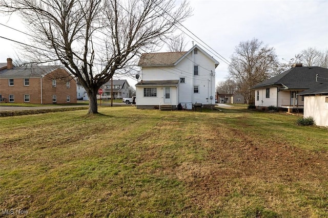 rear view of house featuring a lawn