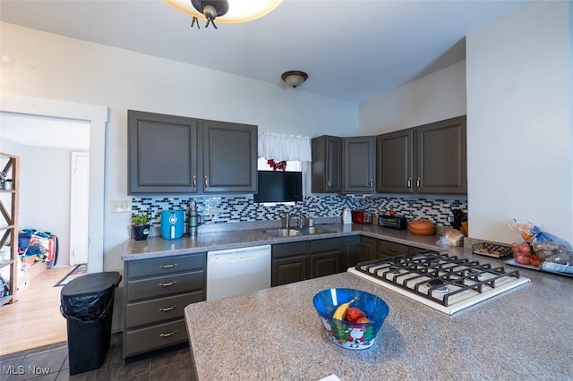 kitchen featuring sink, tasteful backsplash, stainless steel dishwasher, and white gas stovetop