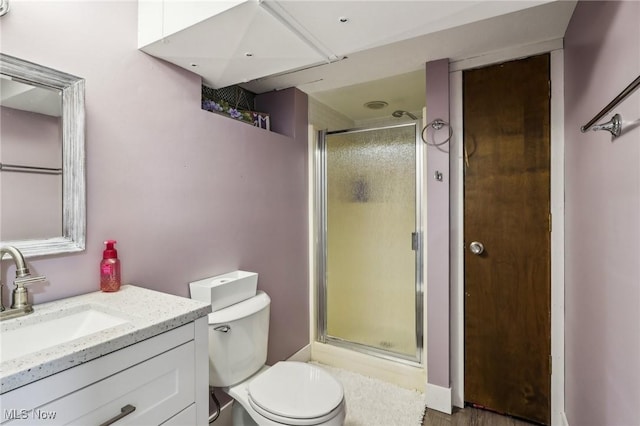 bathroom with toilet, vanity, and walk in shower