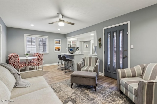 living room with ceiling fan and light wood-type flooring