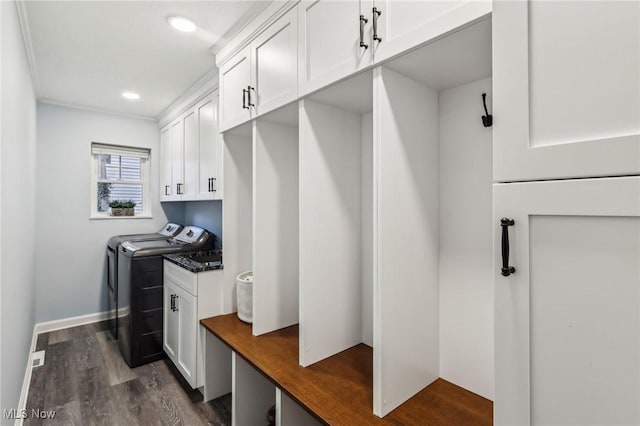 interior space featuring cabinets, dark hardwood / wood-style floors, crown molding, and washing machine and clothes dryer