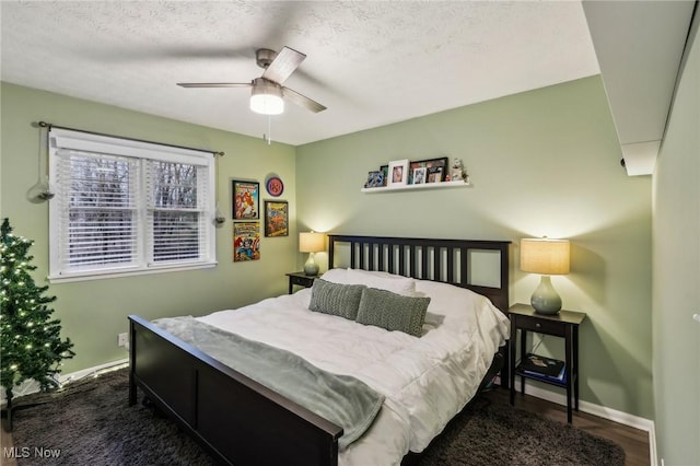 bedroom featuring ceiling fan, dark hardwood / wood-style floors, and a textured ceiling