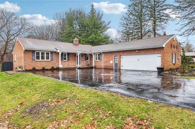 ranch-style home with a garage and a front lawn