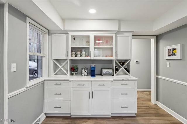 bar featuring white cabinetry and hardwood / wood-style floors