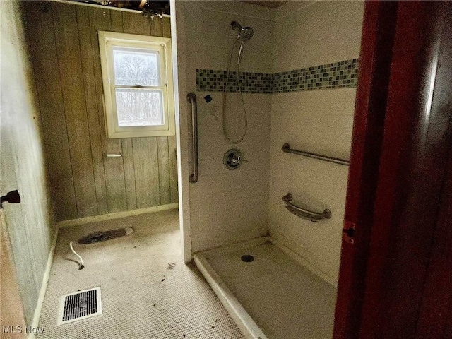 bathroom featuring walk in shower and wood walls