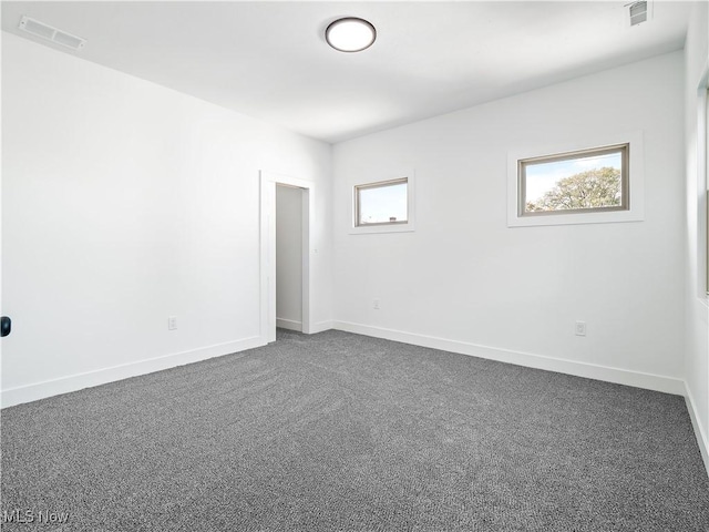 spare room featuring dark carpet