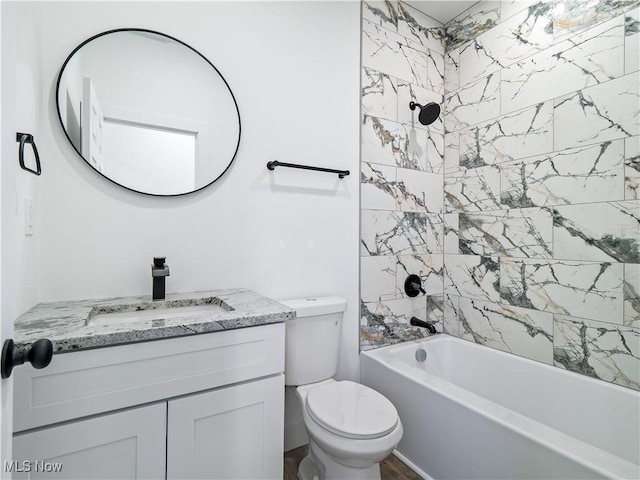 full bathroom featuring tiled shower / bath combo, toilet, and vanity