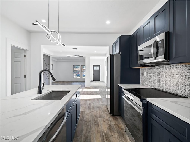 kitchen featuring sink, hanging light fixtures, light stone countertops, tasteful backsplash, and stainless steel appliances