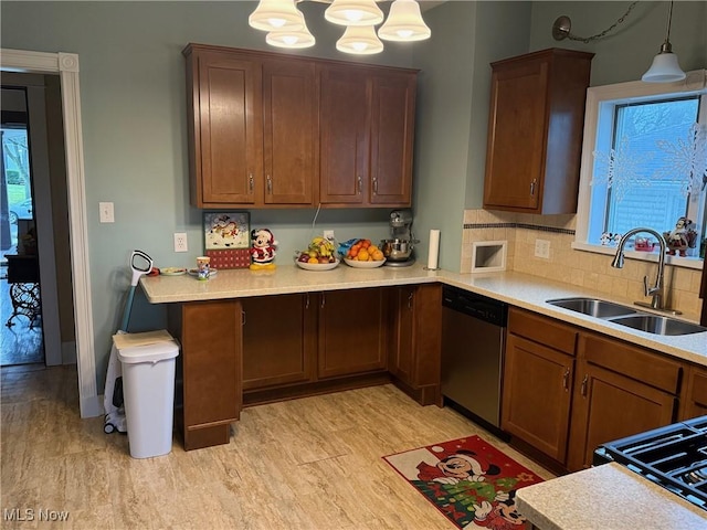 kitchen featuring light wood-type flooring, backsplash, sink, decorative light fixtures, and dishwasher