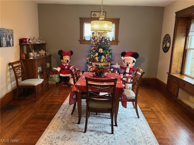 dining room with dark hardwood / wood-style flooring and a notable chandelier