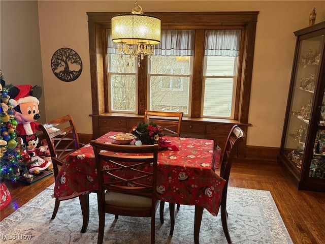 dining room featuring a notable chandelier and dark wood-type flooring