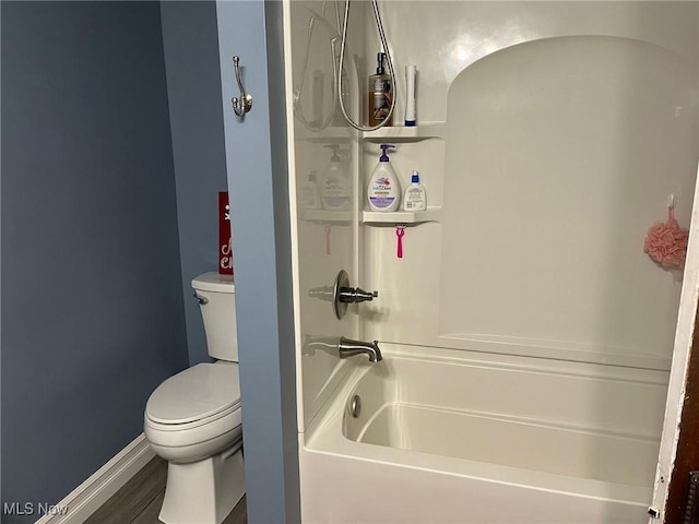 bathroom featuring hardwood / wood-style flooring, toilet, and a bathtub