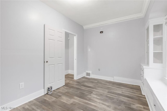 spare room with light hardwood / wood-style floors and crown molding