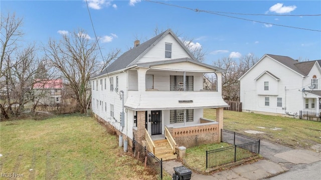 view of front of house with a balcony, a front lawn, and covered porch