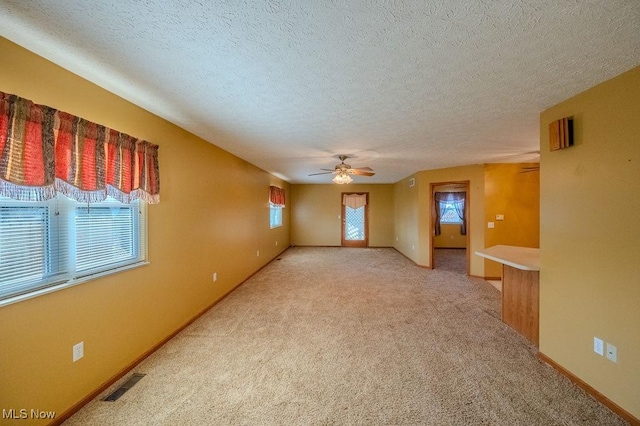 spare room featuring carpet, ceiling fan, and a textured ceiling