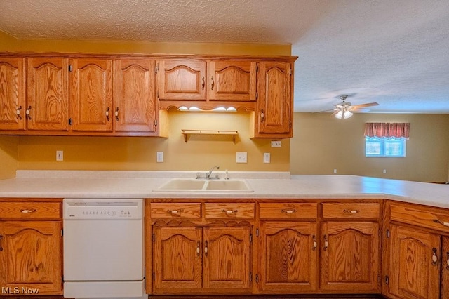 kitchen featuring dishwasher, sink, ceiling fan, a textured ceiling, and kitchen peninsula