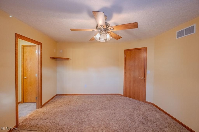 spare room with ceiling fan and light colored carpet