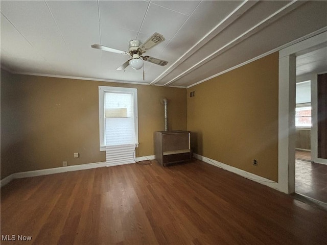 spare room featuring ornamental molding, dark hardwood / wood-style floors, ceiling fan, and a healthy amount of sunlight