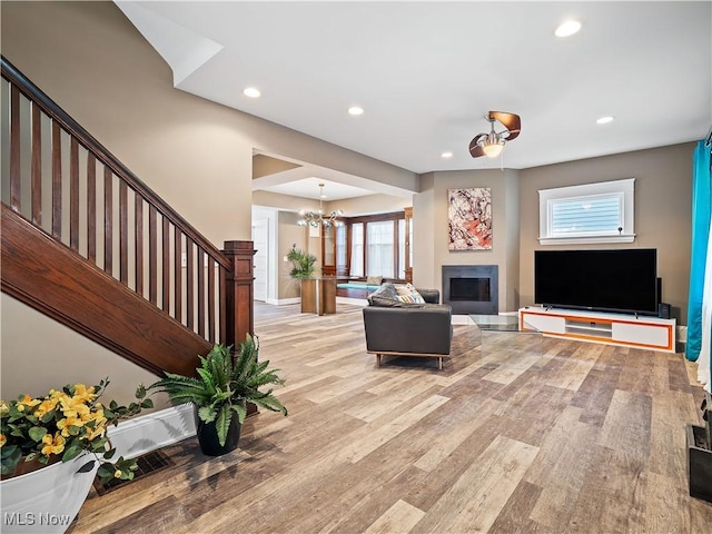 unfurnished living room with a notable chandelier and light wood-type flooring