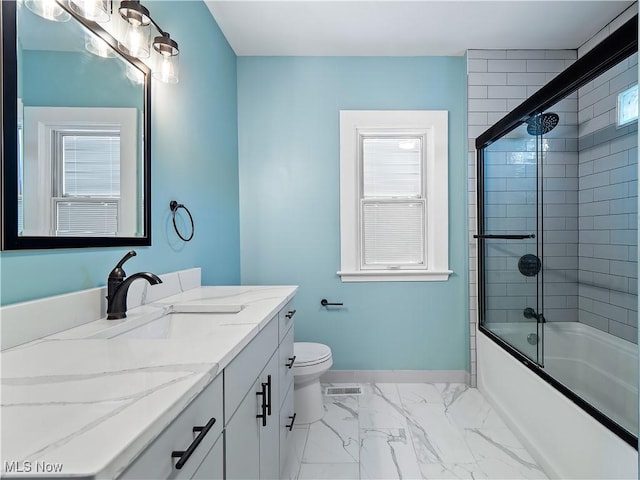 full bathroom featuring vanity, toilet, and combined bath / shower with glass door