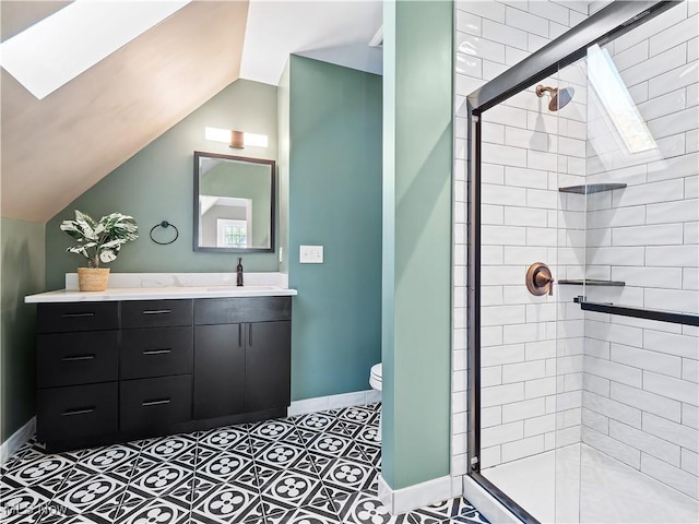 bathroom featuring lofted ceiling with skylight, vanity, a shower with shower door, and toilet