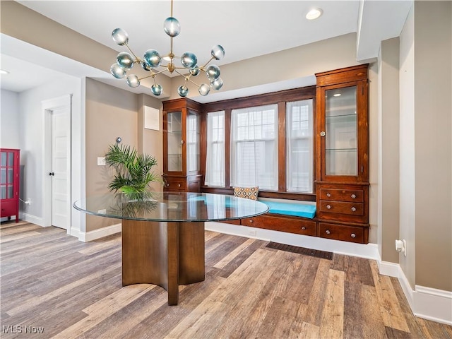 unfurnished dining area featuring light hardwood / wood-style flooring and an inviting chandelier