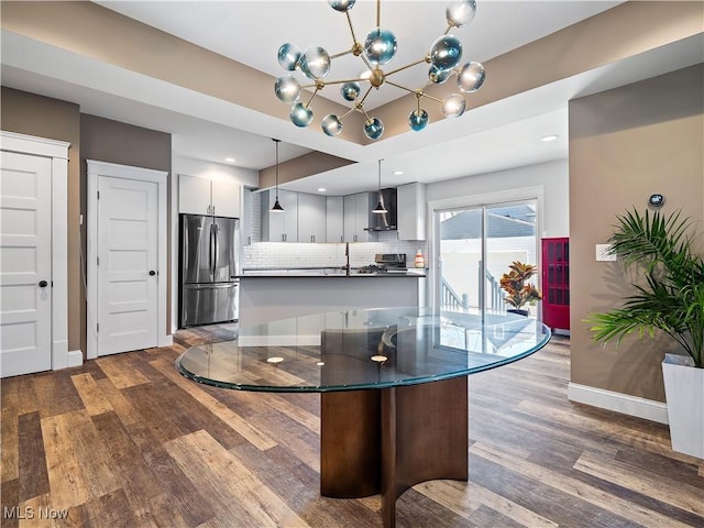 dining space featuring dark hardwood / wood-style flooring, an inviting chandelier, and sink