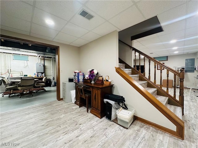 staircase with a paneled ceiling and hardwood / wood-style flooring