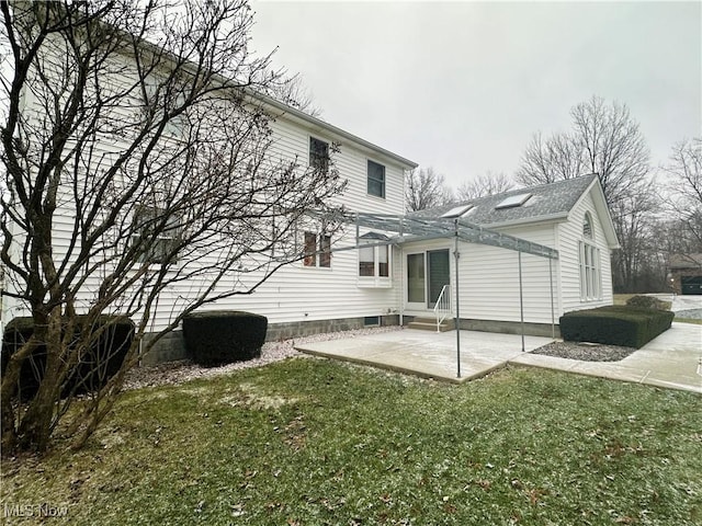 rear view of house featuring a yard and a patio area