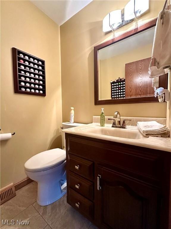 bathroom featuring tile patterned floors, vanity, and toilet