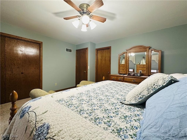 bedroom with ceiling fan and multiple closets