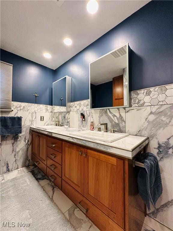 bathroom featuring vanity and tile walls