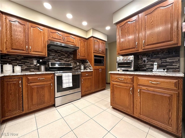 kitchen with decorative backsplash, stainless steel appliances, light stone counters, and light tile patterned flooring