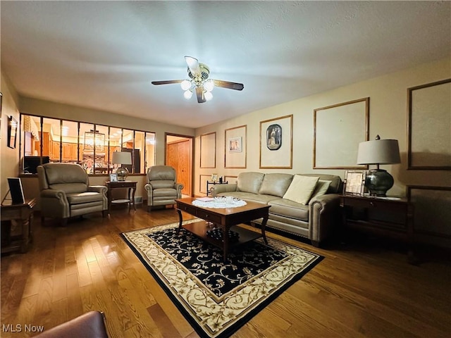 living room with dark hardwood / wood-style flooring and ceiling fan