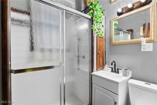 bathroom featuring vanity, toilet, and walk in shower