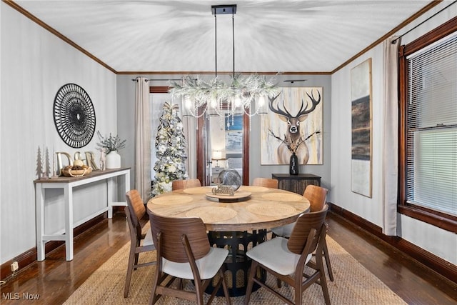 dining room with dark hardwood / wood-style flooring, an inviting chandelier, and ornamental molding