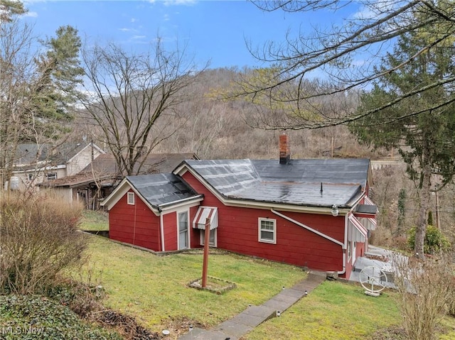 rear view of house featuring a yard