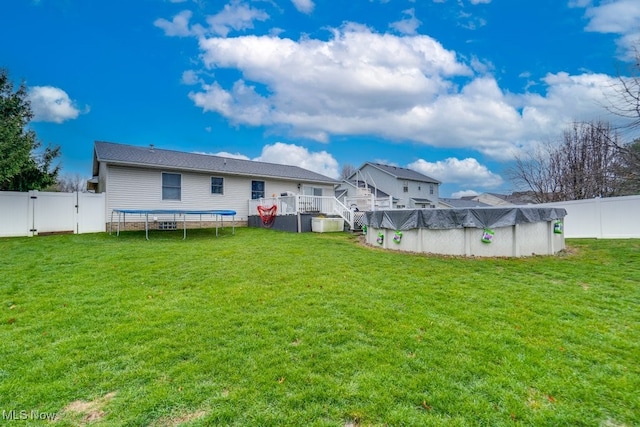 view of yard with a swimming pool side deck and a trampoline