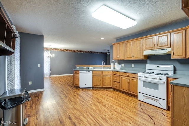 kitchen with white appliances, an inviting chandelier, sink, light hardwood / wood-style flooring, and a textured ceiling