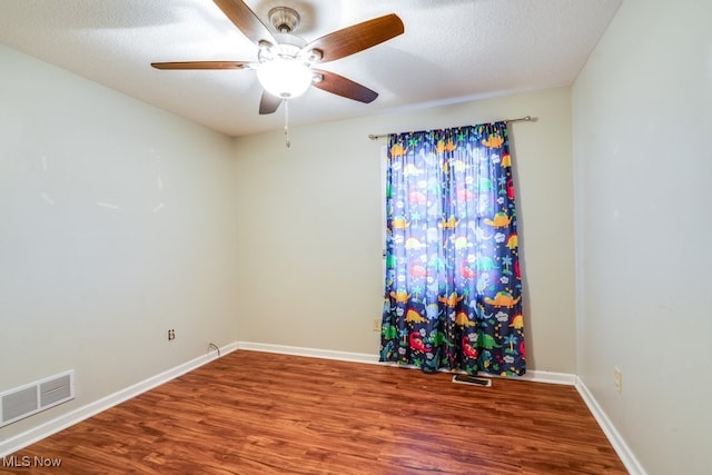 unfurnished room featuring hardwood / wood-style flooring, ceiling fan, and a textured ceiling