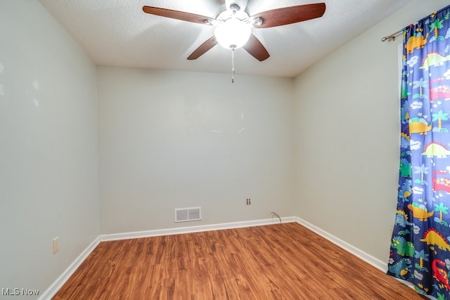 empty room with wood-type flooring, a textured ceiling, and ceiling fan