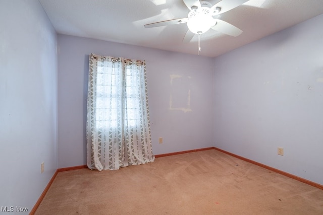 spare room featuring ceiling fan and light colored carpet