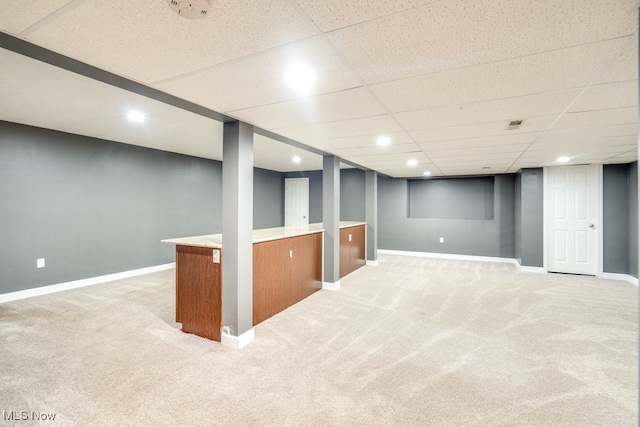 basement with light colored carpet and a drop ceiling