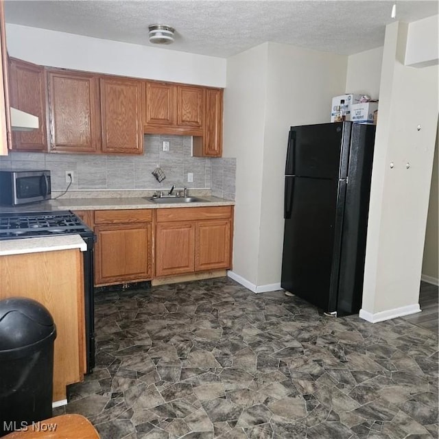 kitchen featuring sink, backsplash, extractor fan, black appliances, and a textured ceiling