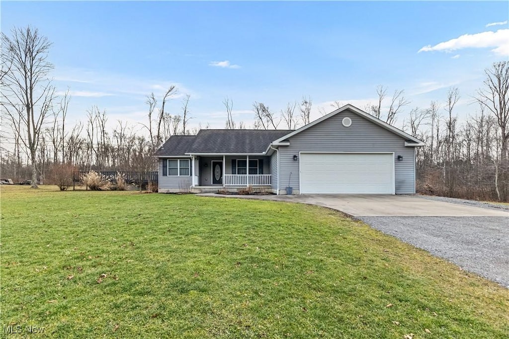 ranch-style house with covered porch, a garage, and a front lawn